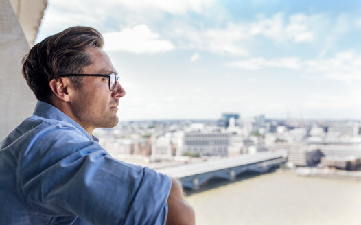 UK, London, Mann betrachtet die Stadt auf einer Dachterrasse - MGOF03818