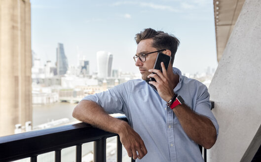 UK, London, Mann am Telefon auf einer Dachterrasse - MGOF03820