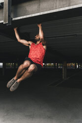 Young man exercising pull-ups - UUF15573