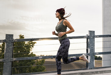 Junge Frau beim Joggen am Morgen - UUF15575