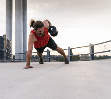 Young man training with dumbbell - UUF15583