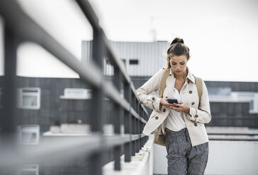 Young businesswoman using smartphone in he city - UUF15637