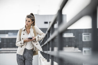 Young businesswoman using smartphone in he city - UUF15638