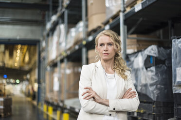 Portrait of confident woman in factory storehouse - DIGF05324