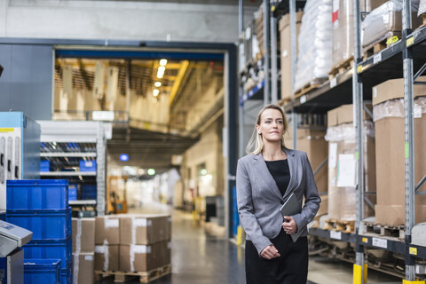 Portrait of confident woman with tablet in factory storehouse stock photo