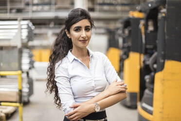 Portrait of confident woman in factory shop floor - DIGF05344