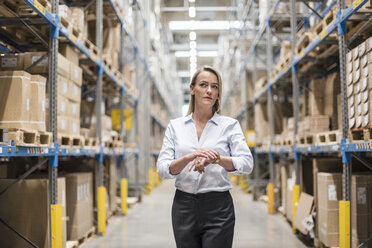 Woman in factory storehouse looking around - DIGF05360