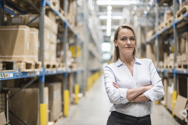 Portrait of confident woman in factory storehouse - DIGF05361