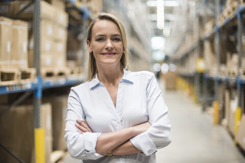 Portrait of smiling woman in factory storehouse stock photo