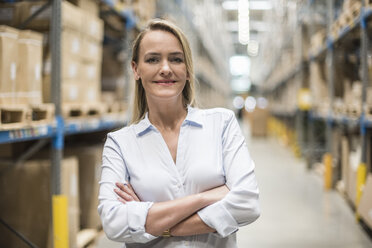 Portrait of smiling woman in factory storehouse - DIGF05363