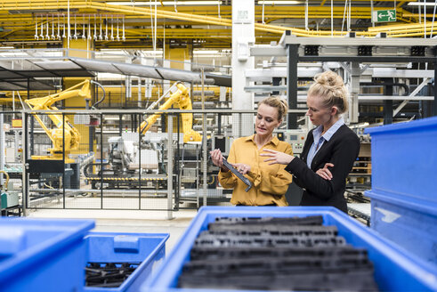 Zwei Frauen begutachten ein Werkstück in einer Fabrik - DIGF05406