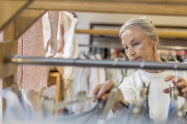 Senior woman shopping for clothes in a boutique - VGF00023