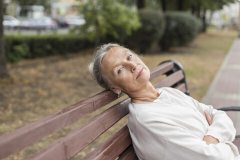 Porträt einer älteren Frau, die sich auf einer Bank ausruht, lizenzfreies Stockfoto