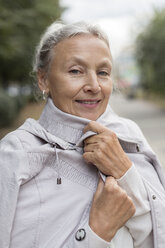 Porträt einer lächelnden älteren Frau in einem Mantel - VGF00068