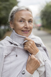 Porträt einer lächelnden älteren Frau in einem Mantel - VGF00069