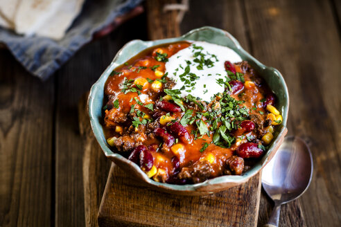 Chili con carne with kidney beans and corn, sour cream, parsley, tortilla bread - SBDF03782