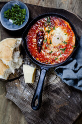 Eier im Fegefeuer, Eier, gebacken in sehr würziger Tomatensauce, bestreut mit Petersilie und Parmesan - SBDF03787