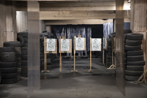 Tafeln mit männlichem Konterfei als Zielscheiben in einer Indoor-Schießanlage - KKAF02577