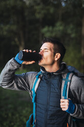 Man camping in Estonia, drinking water - KKA02772