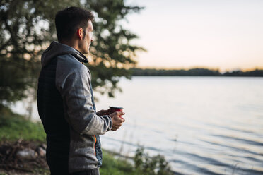 Mann schaut auf den See, trinkt Kaffee - KKA02786