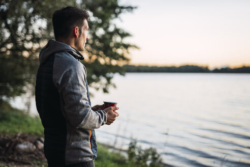 Man looking at the lake, drinking coffee - KKA02786