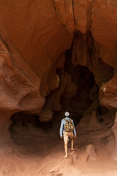 Junger Mann mit Rucksack, Blick auf Höhle, Rückansicht - AFVF01874