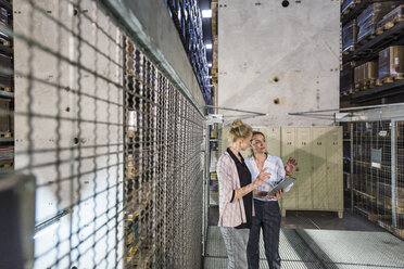 Frauen benutzen Laptop im Hochregallager - DIGF05423