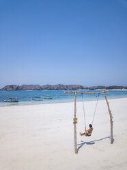 Indonesia, Lombok, young woman on a swing - KNTF02227