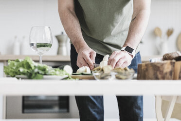 Man preparing salad at home, partial view - KMKF00597