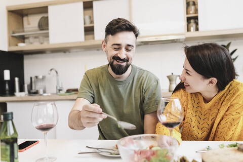 Glückliches verliebtes Paar beim gemeinsamen Mittagessen zu Hause, lizenzfreies Stockfoto