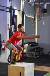 Man doing box jumps in a gym - JSMF00503