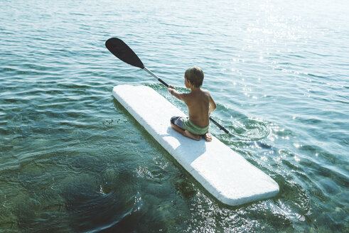 Rückansicht eines Jungen ohne Hemd, der auf einem See paddelt - CAVF50624