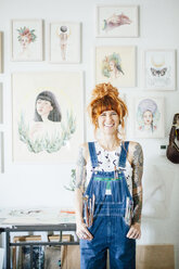 Porträt eines lächelnden Künstlers mit Händen in den Taschen im Atelier stehend - CAVF50686