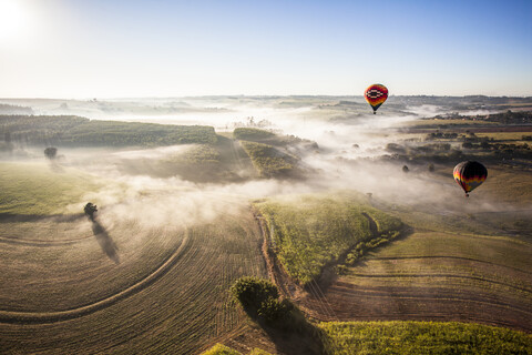 Luftaufnahme von Heißluftballons fliegen über Landschaft gegen Himmel während sonnigen Tag, lizenzfreies Stockfoto