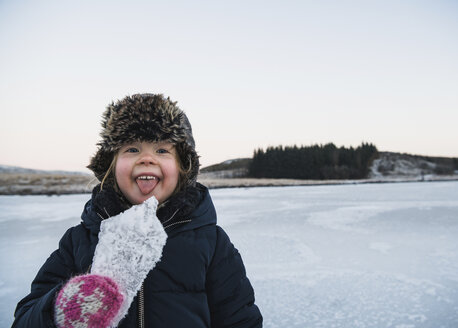 Portrait of playful girl sticking out tongue while holding ice - CAVF50749