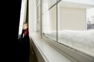 Portrait of playful boy standing behind curtains at home - CAVF50765