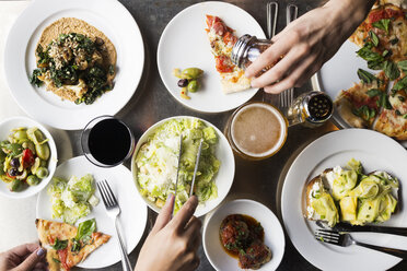 Cropped hands of friends serving food on table - CAVF50769