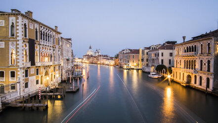 Light trails over Grand Canal amidst buildings in city during sunset - CAVF50785