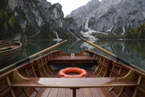 Ausgeschnittenes Bild eines Bootes, das auf einem ruhigen See am Berg vertäut ist, lizenzfreies Stockfoto