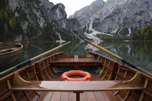 Ausgeschnittenes Bild eines Bootes, das auf einem ruhigen See am Berg vertäut ist - CAVF50794