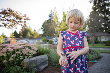 Girl with butterfly standing by plants against sky at park - CAVF50798