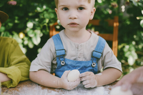 Porträt eines Jungen, der mit seinem Bruder im Hof Essen zubereitet, lizenzfreies Stockfoto