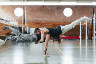 Full length side view of gymnasts practicing handstand at gym - CAVF50852