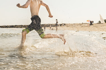 Tiefschnitt eines Teenagers, der am Strand läuft - CAVF50878