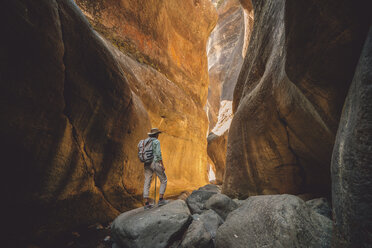 Seitenansicht einer Wanderin mit Rucksack auf einem Felsen stehend - CAVF50885