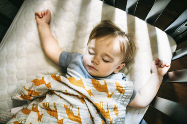 Draufsicht auf ein süßes Baby, das zu Hause in einem Kinderbett schläft - CAVF50905