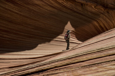 Hiker with backpack standing on Marble Canyon during sunny day - CAVF50934