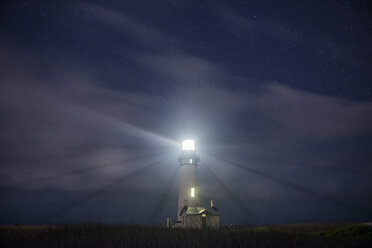 Low angle view of illuminated Yaquina Head Light against sky at night - CAVF50946