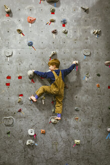 Rear view of boy climbing wall at health club - CAVF51020