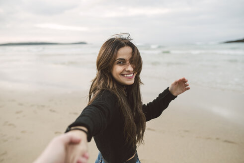 Portrait of smiling young woman holding hands on the beach - RAEF02198